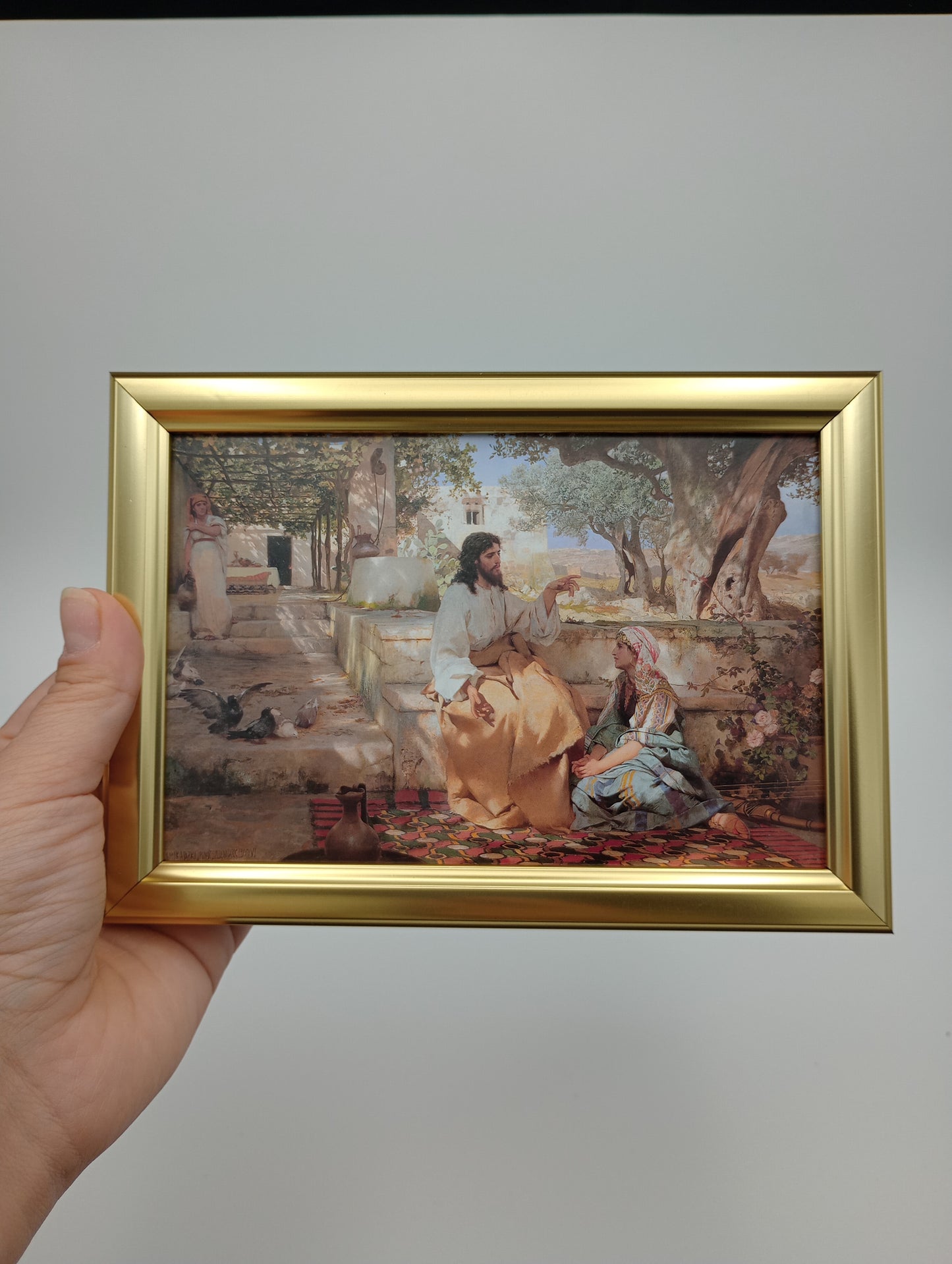 a person holding up a picture of a painting