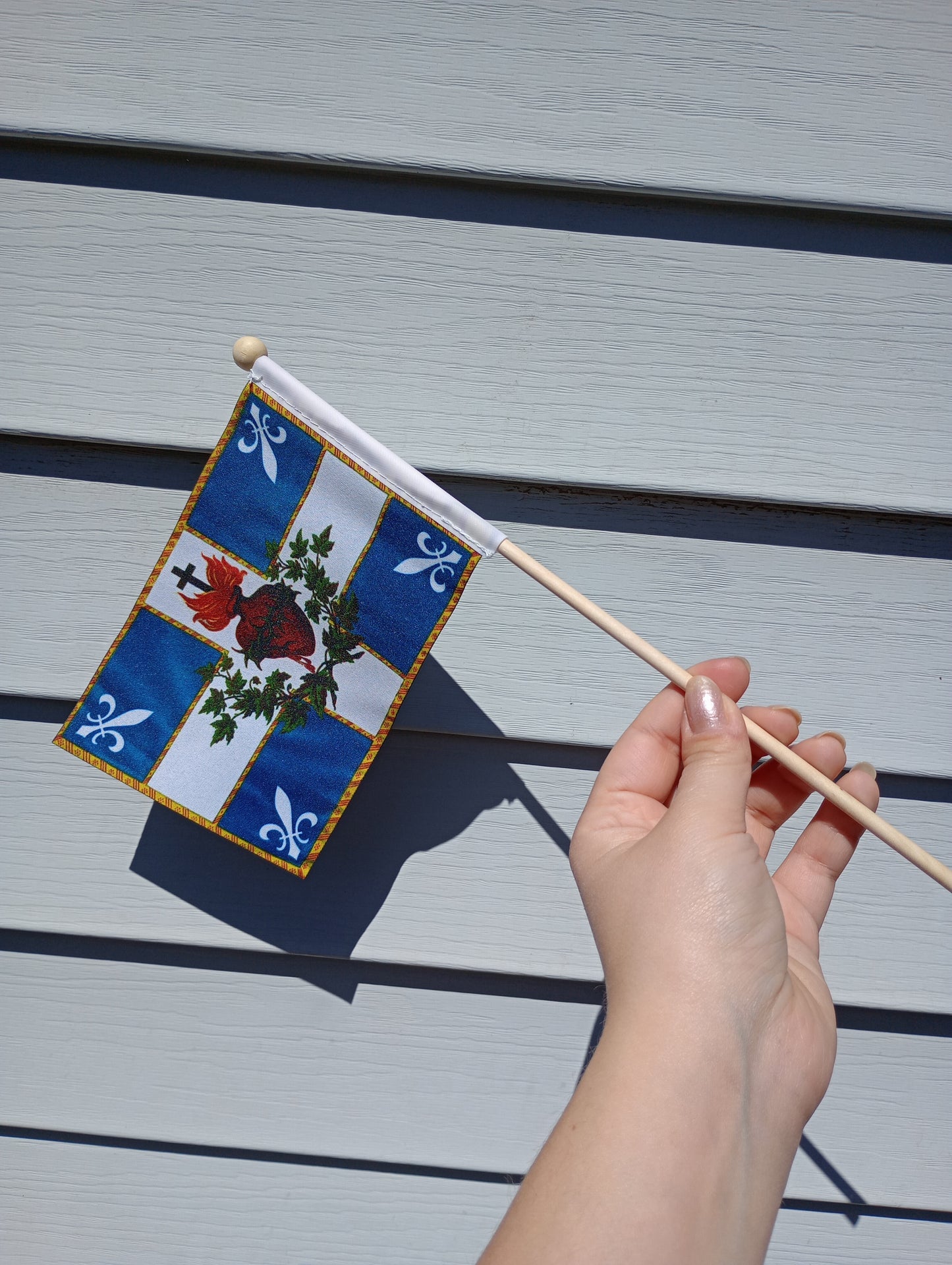 a hand holding a stick with a christmas decoration on it