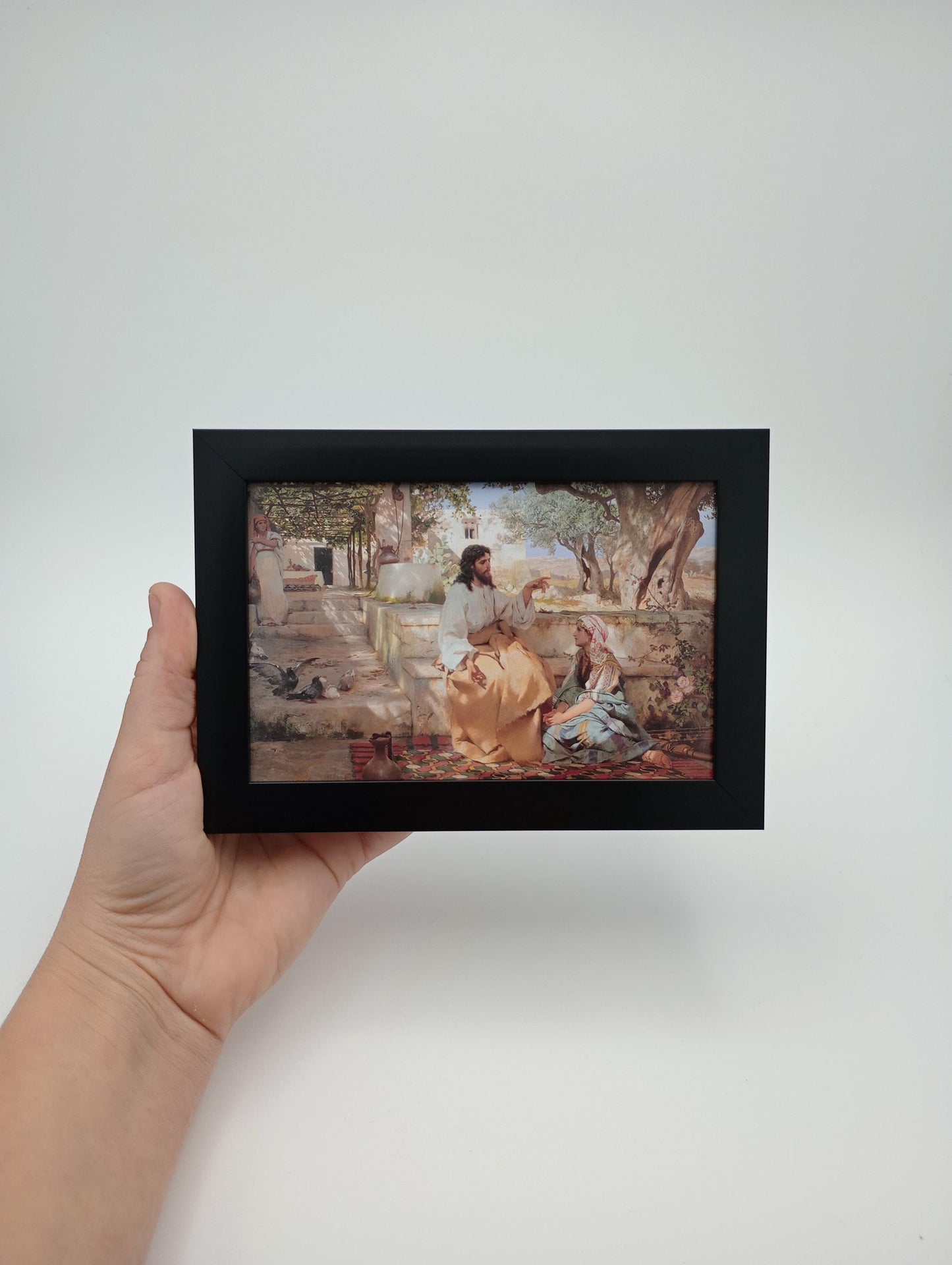 a person holding up a picture of a painting