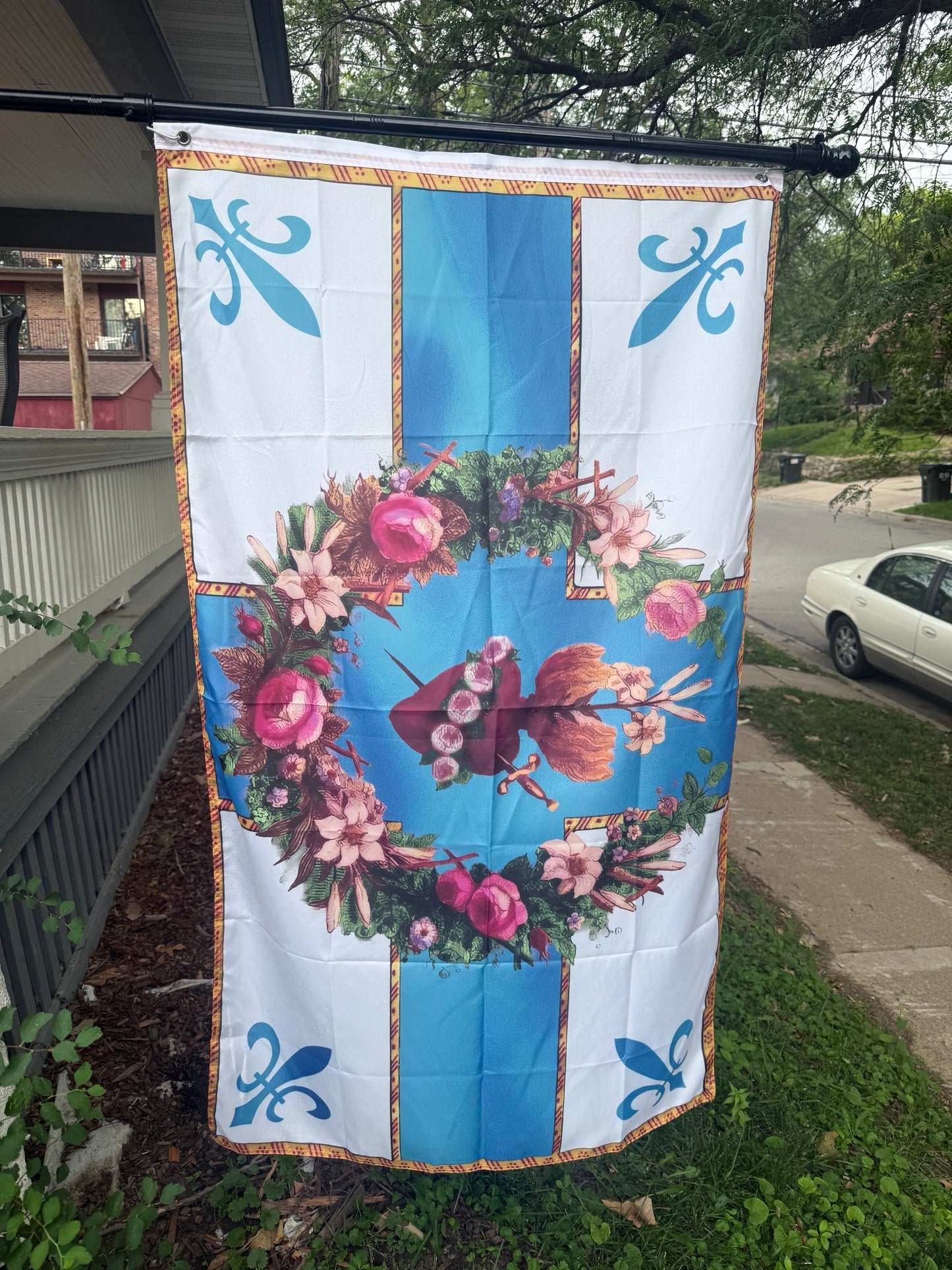 a large flag with a floral design and blue accents, hanging on a pole.