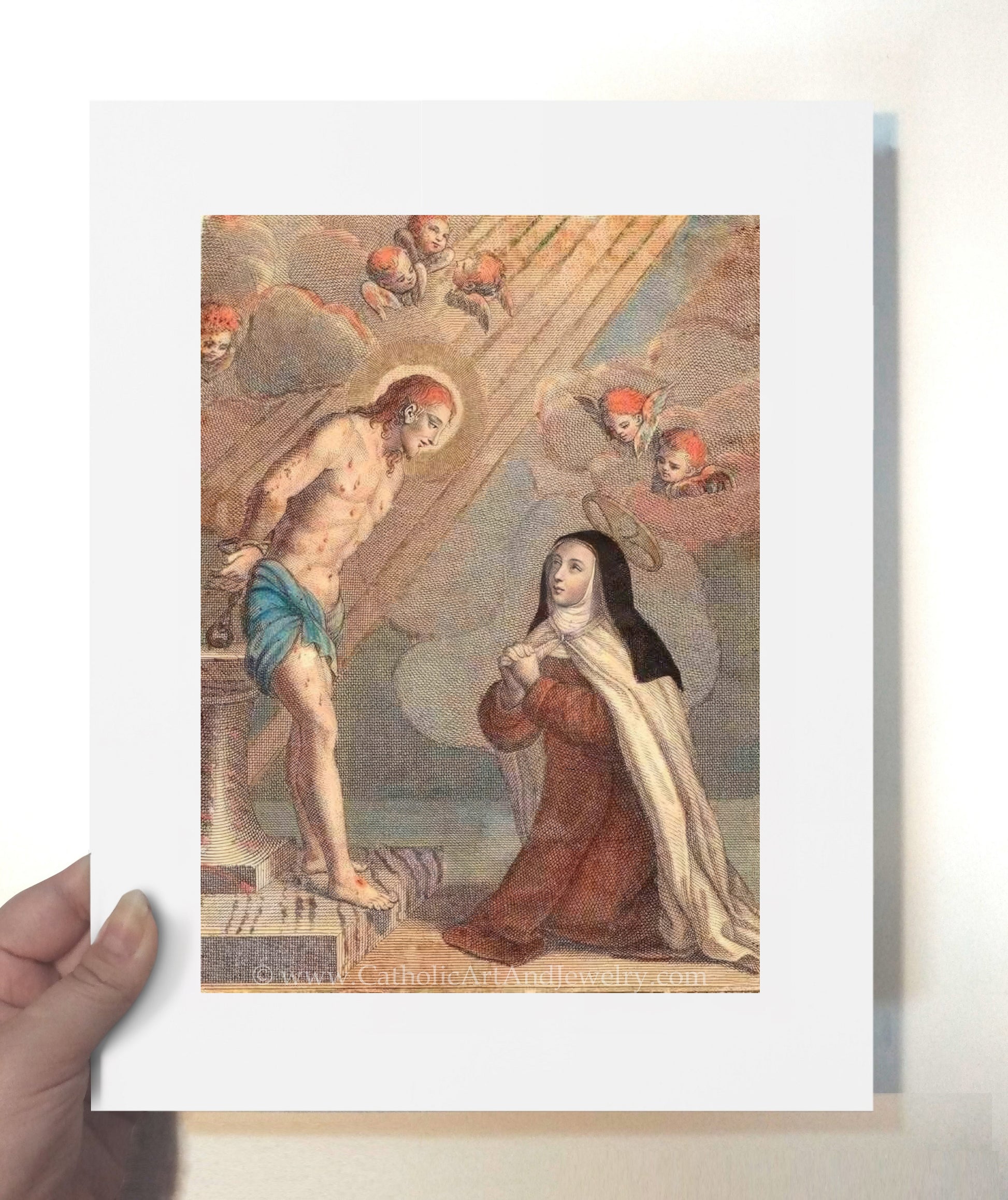 a person holding a card with a painting of jesus and mary