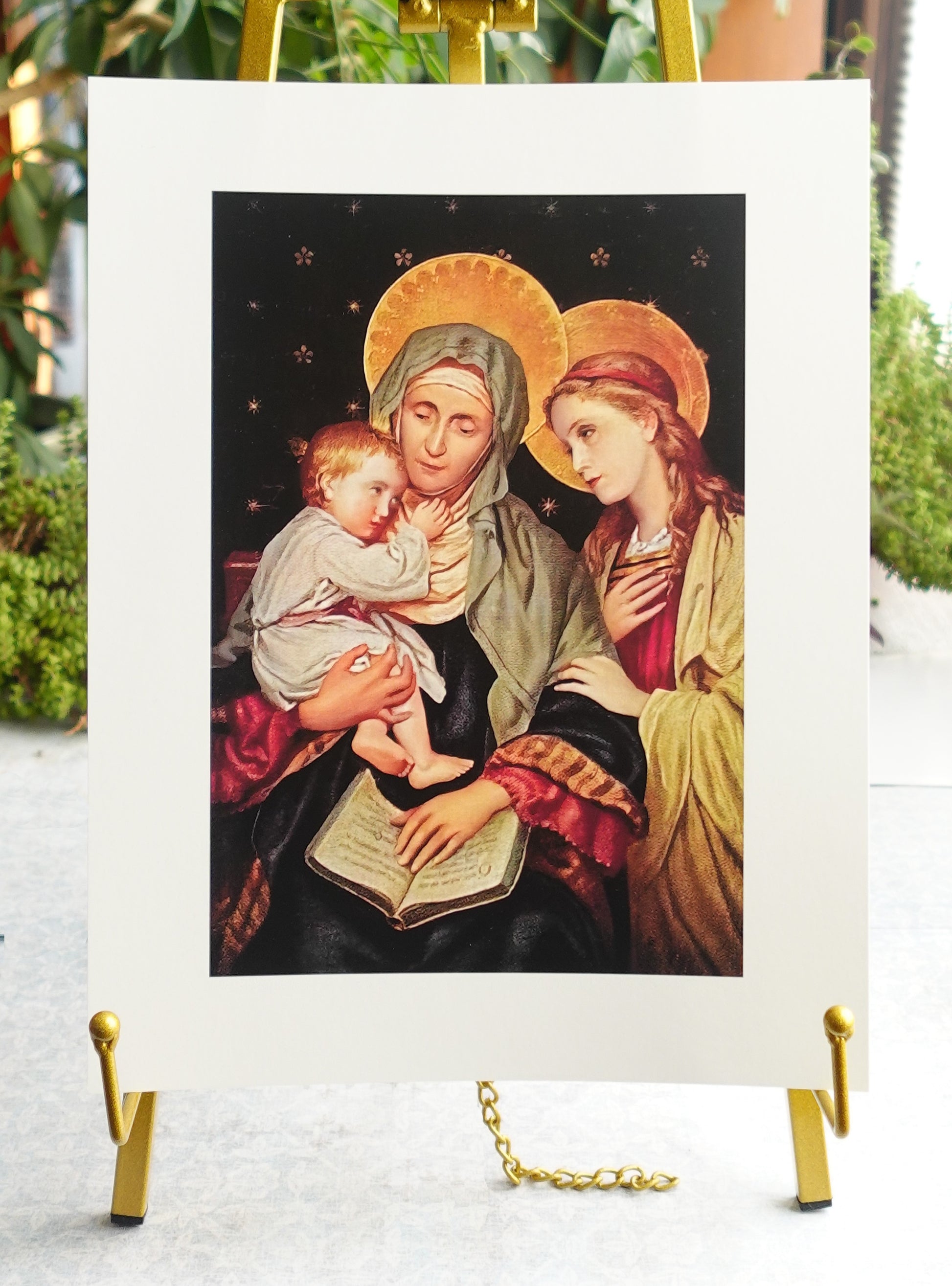 a religious scene with two women, one holding a baby, and a book, all wearing robes and head coverings.