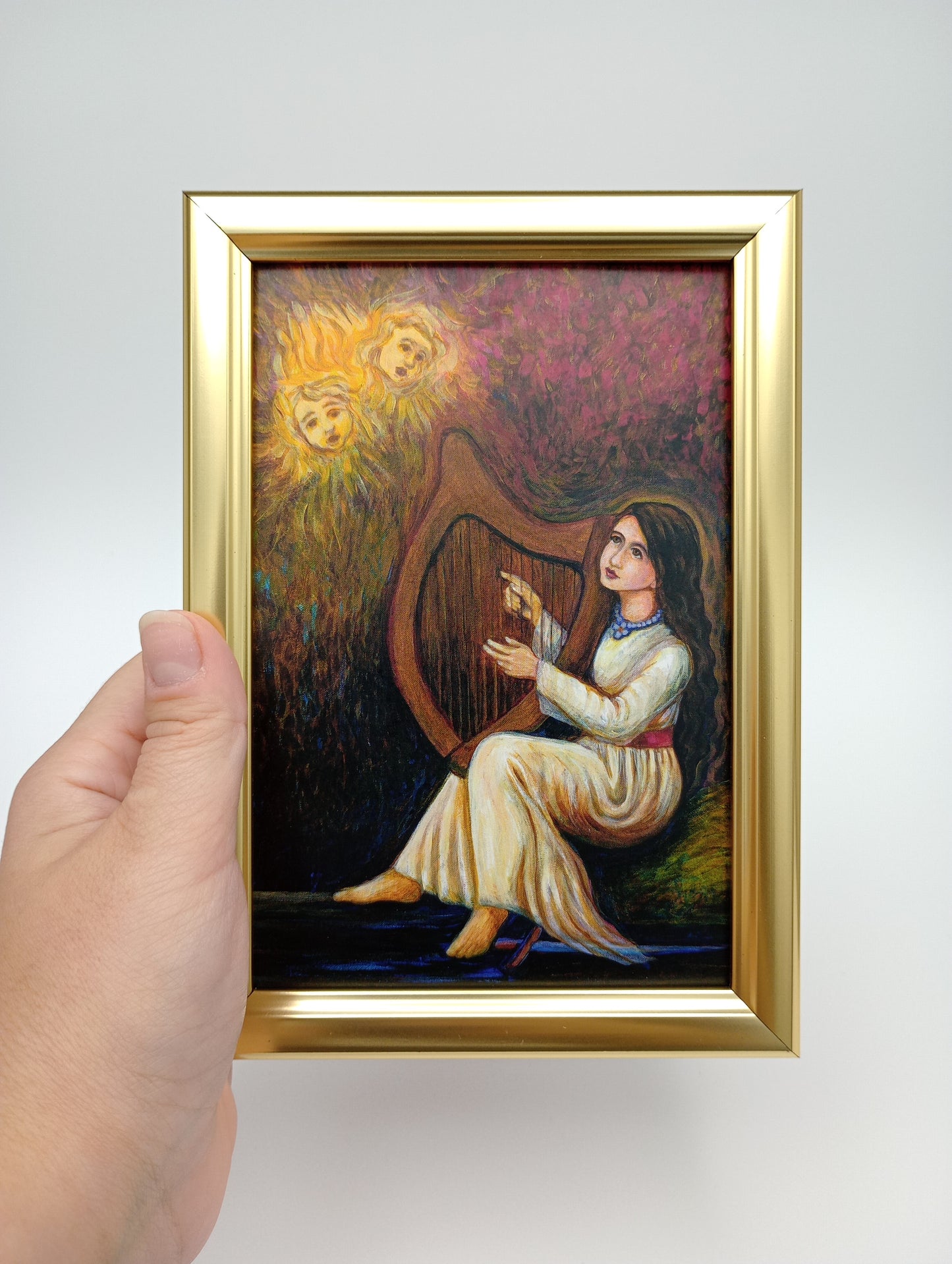 a person holding a painting of a woman and a lion