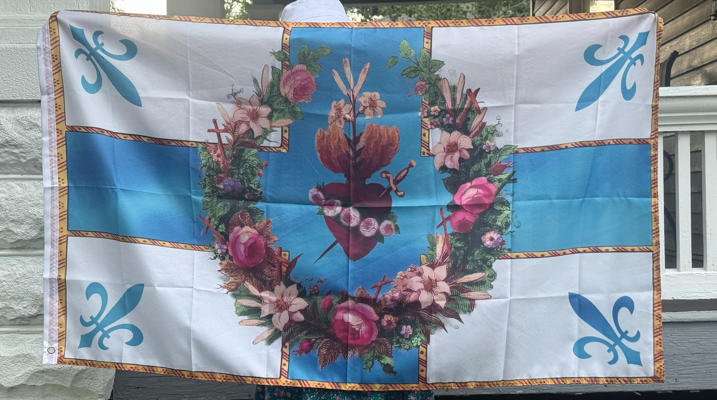 A person is holding a large flag with a floral design and a heart-shaped emblem in the center.