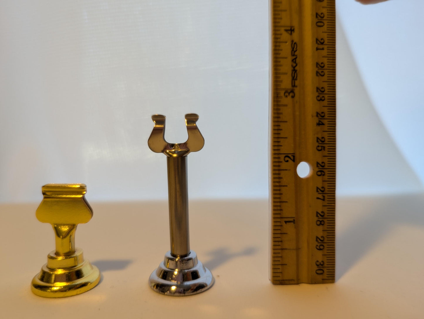 three small objects placed next to each other, with a ruler placed between them.