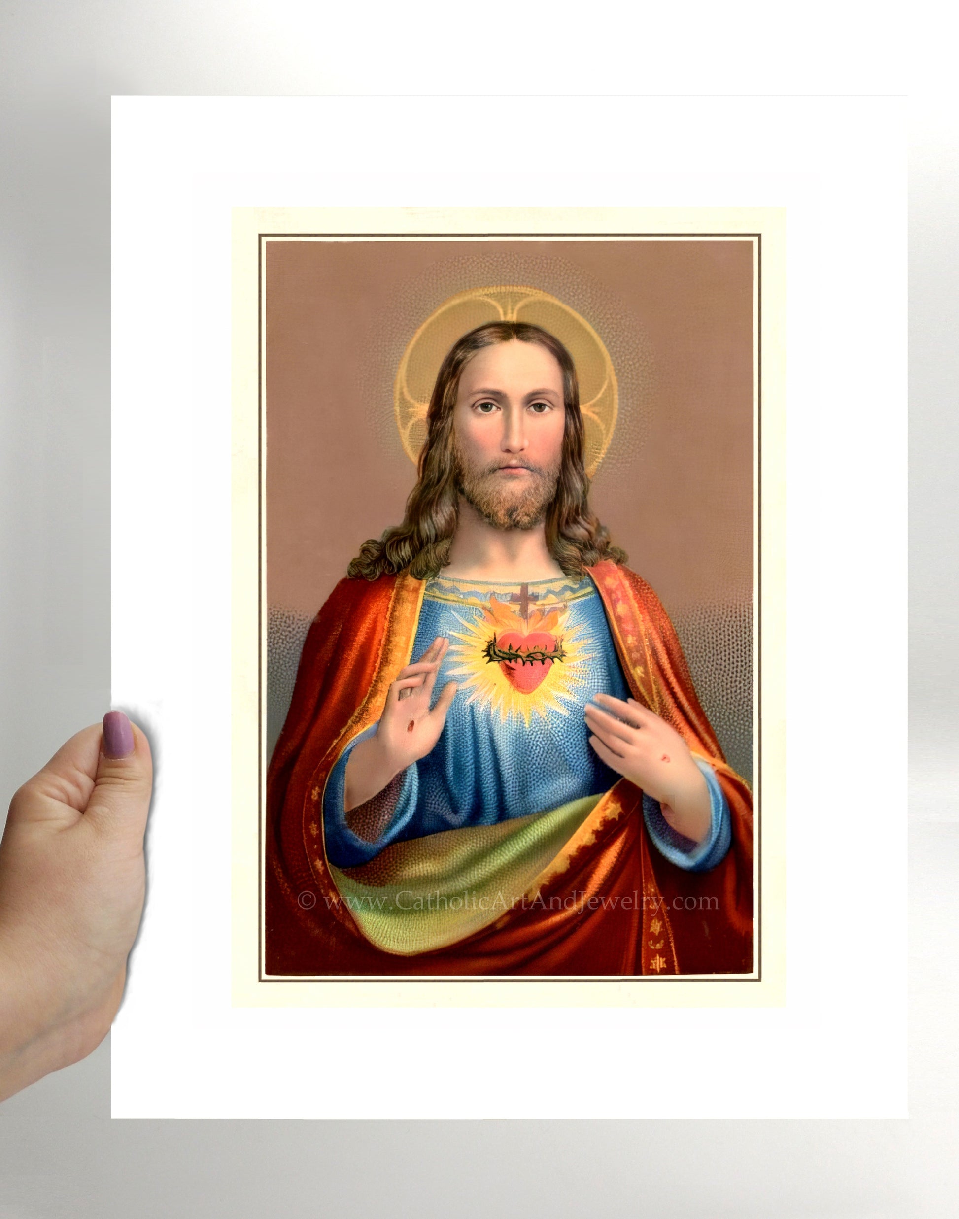 a hand holding up a picture of jesus