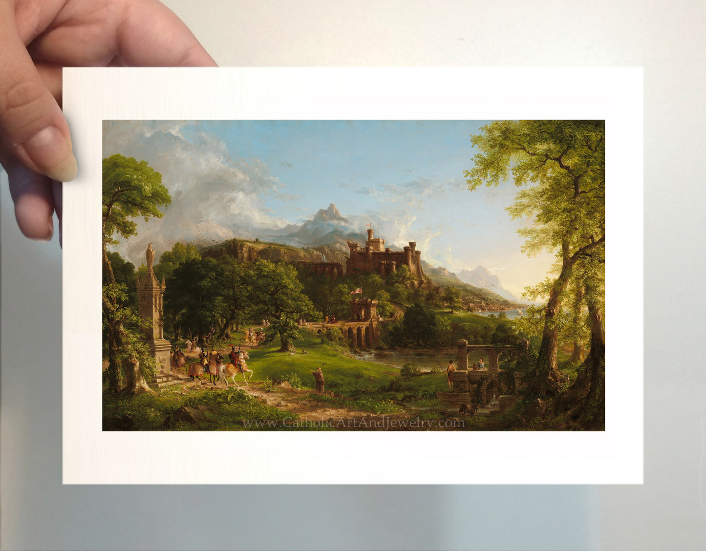 a person holding a picture of a castle in a forest