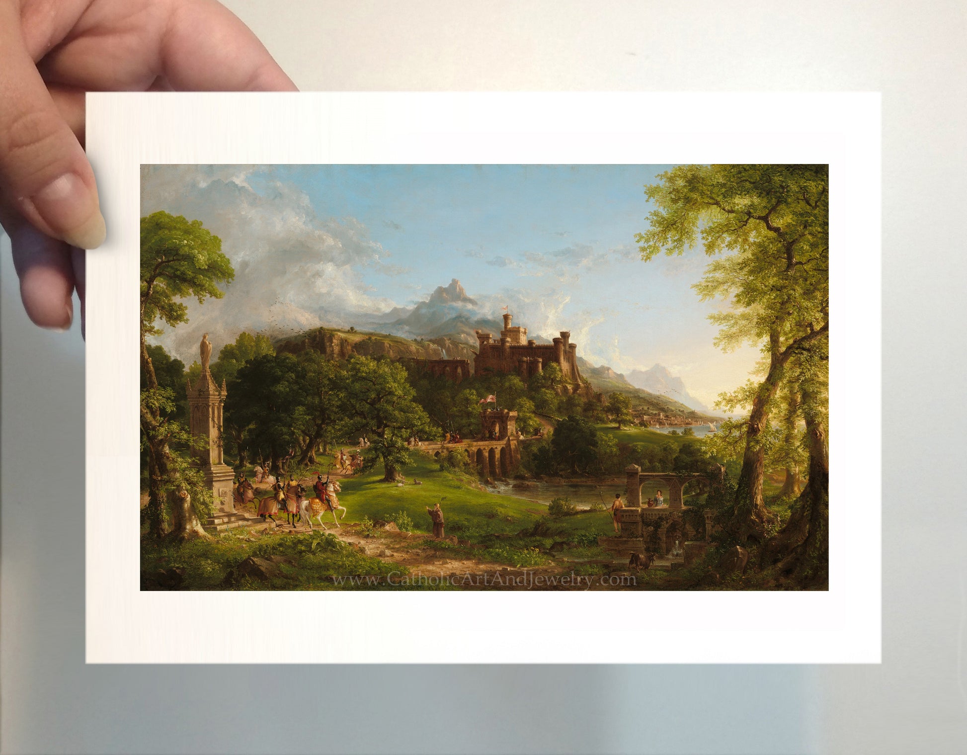 a person holding a picture of a castle in a forest