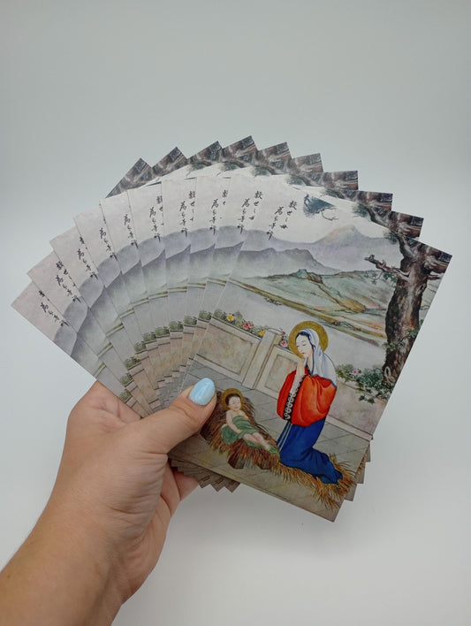 a hand holding a bunch of cards with a painting on them