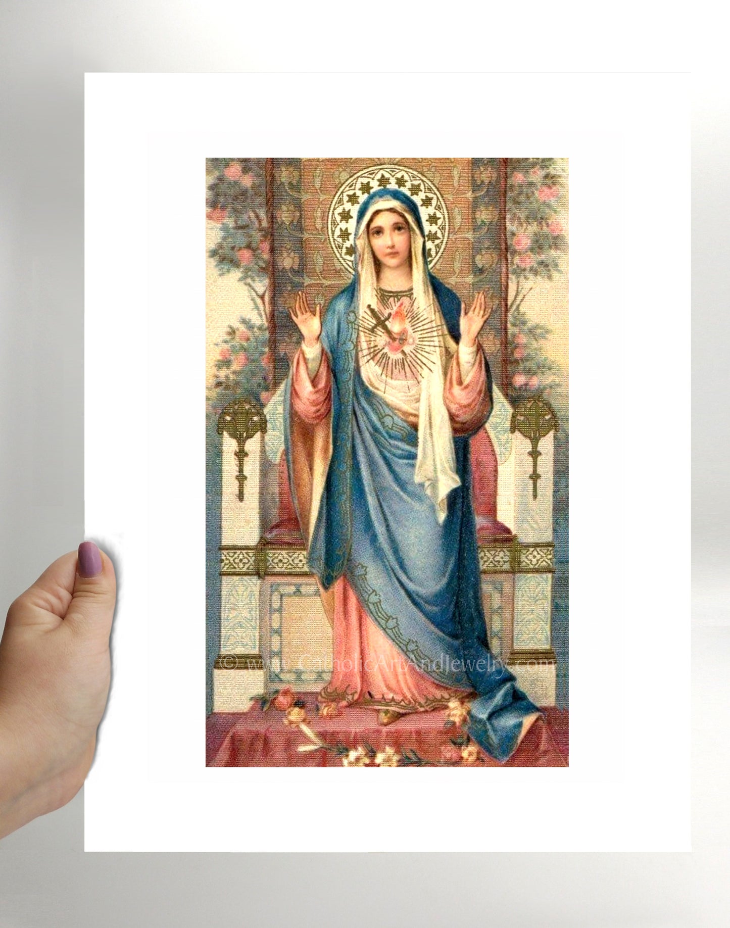 a hand holding a card with a picture of the virgin mary