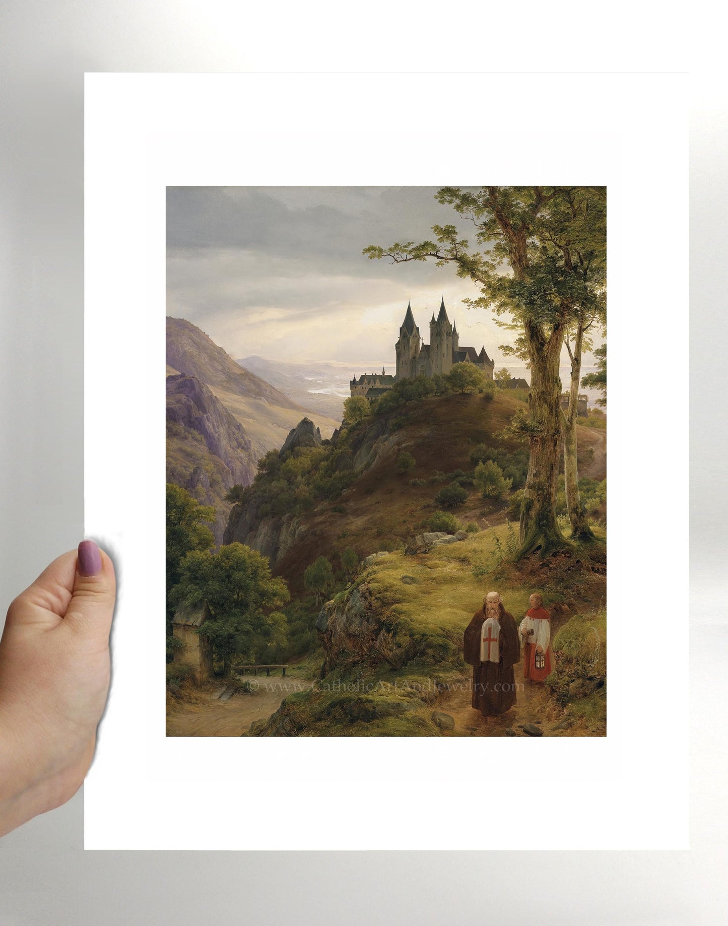 a person holding a picture of a castle on a hill