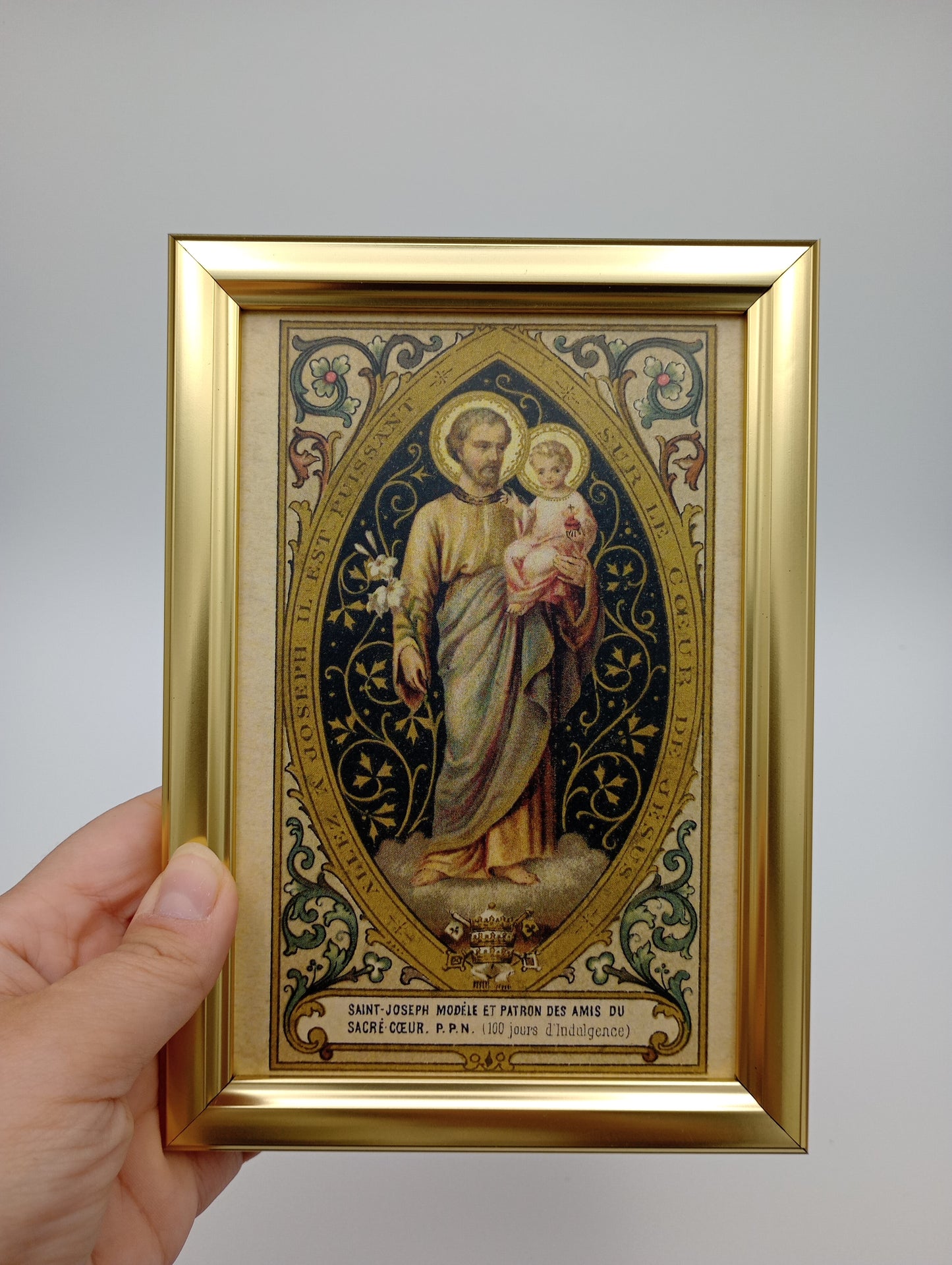 a hand holding a framed picture of a woman