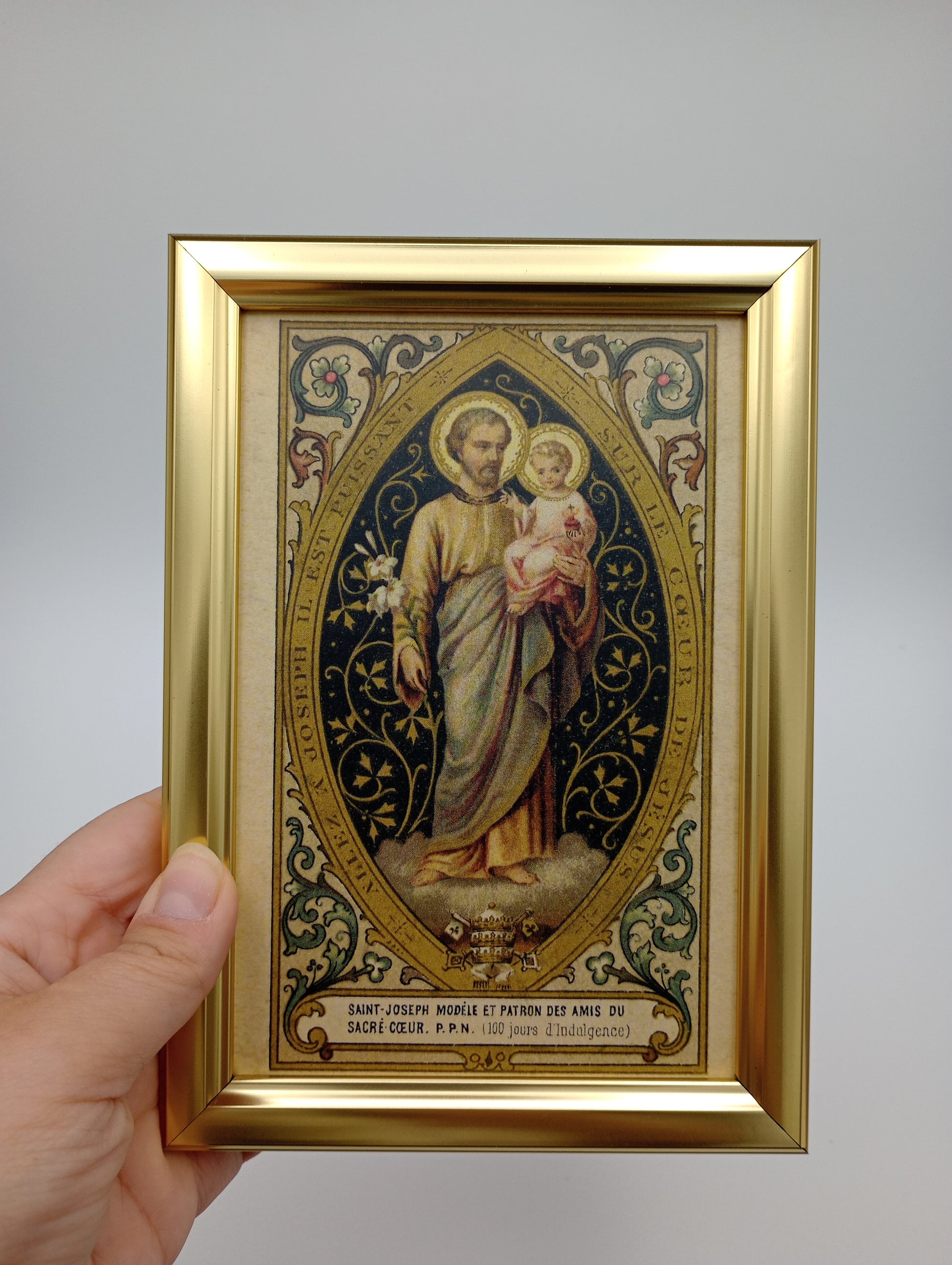 a hand holding a framed picture of a woman