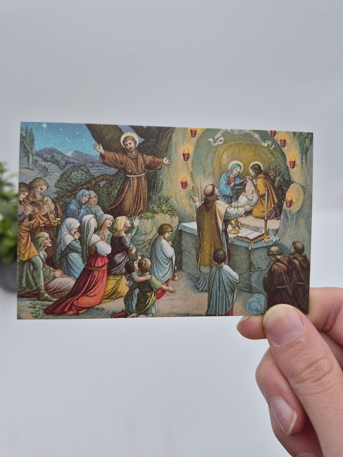 a hand holding up a card with a picture of jesus