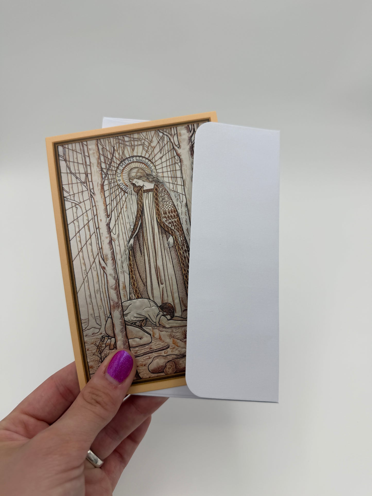 A hand holding an envelope with a framed illustration of a person sitting on a bench.