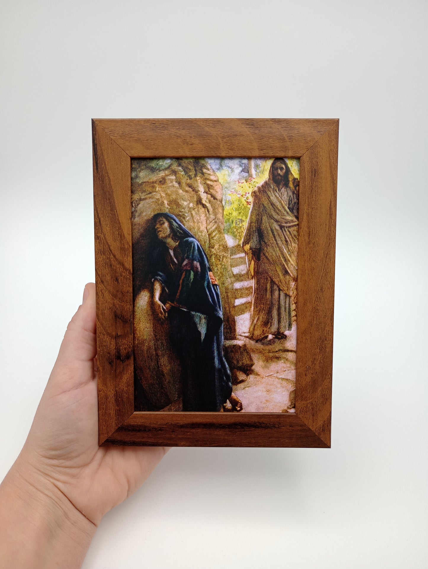 a person holding a picture in a wooden frame