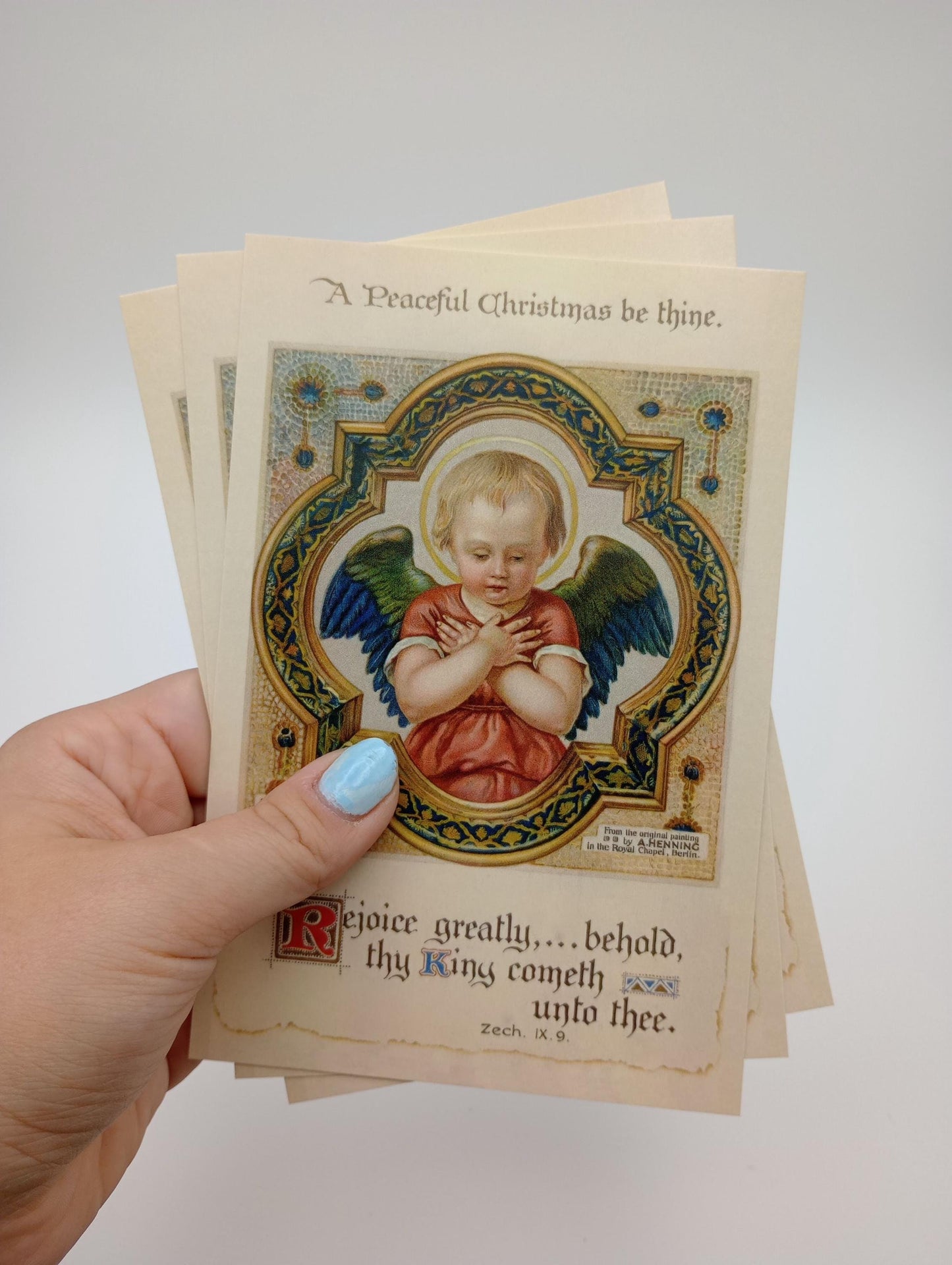 a hand holding a card with a picture of an angel on it