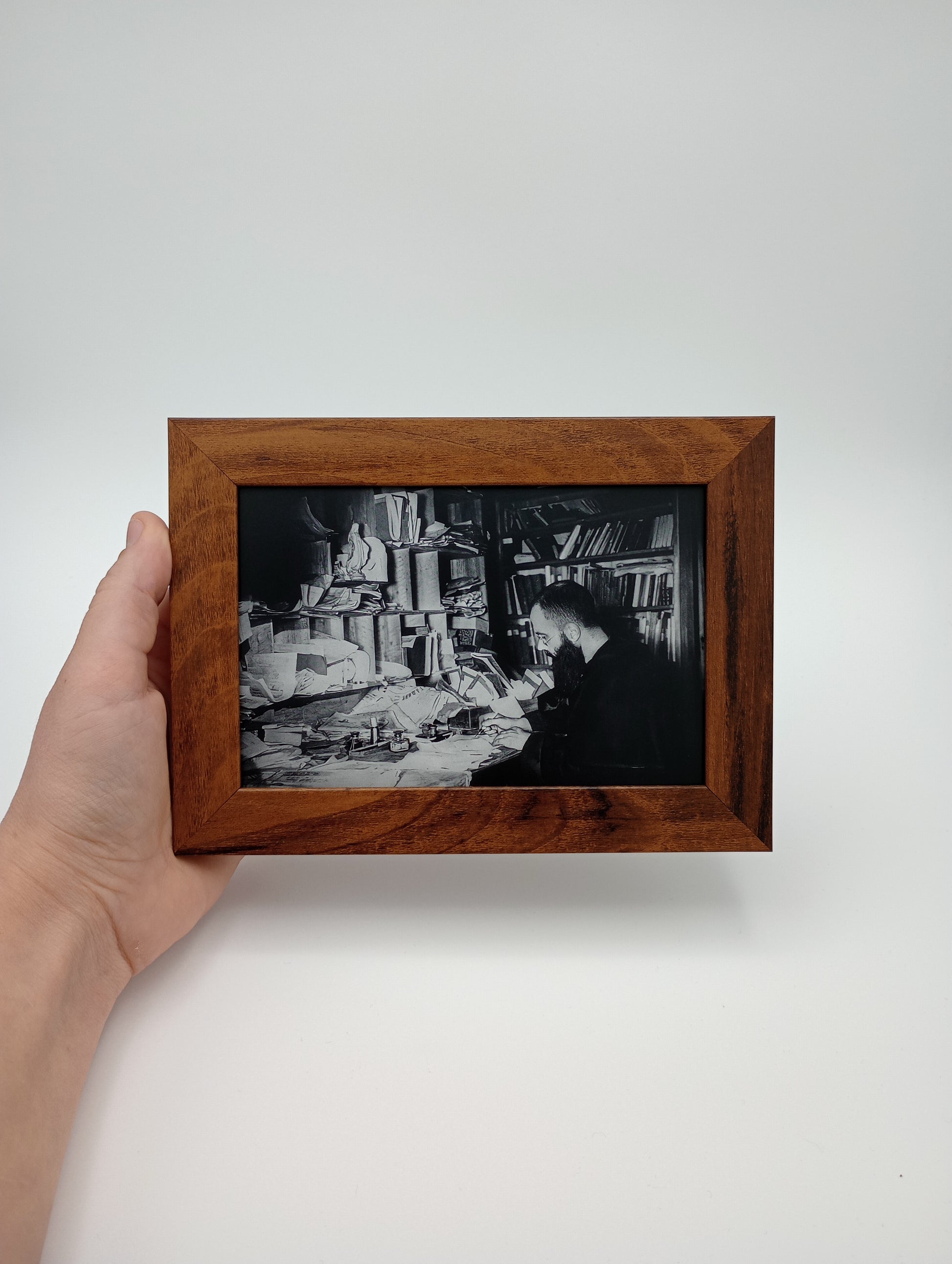 a hand holding a picture of a man in a suit