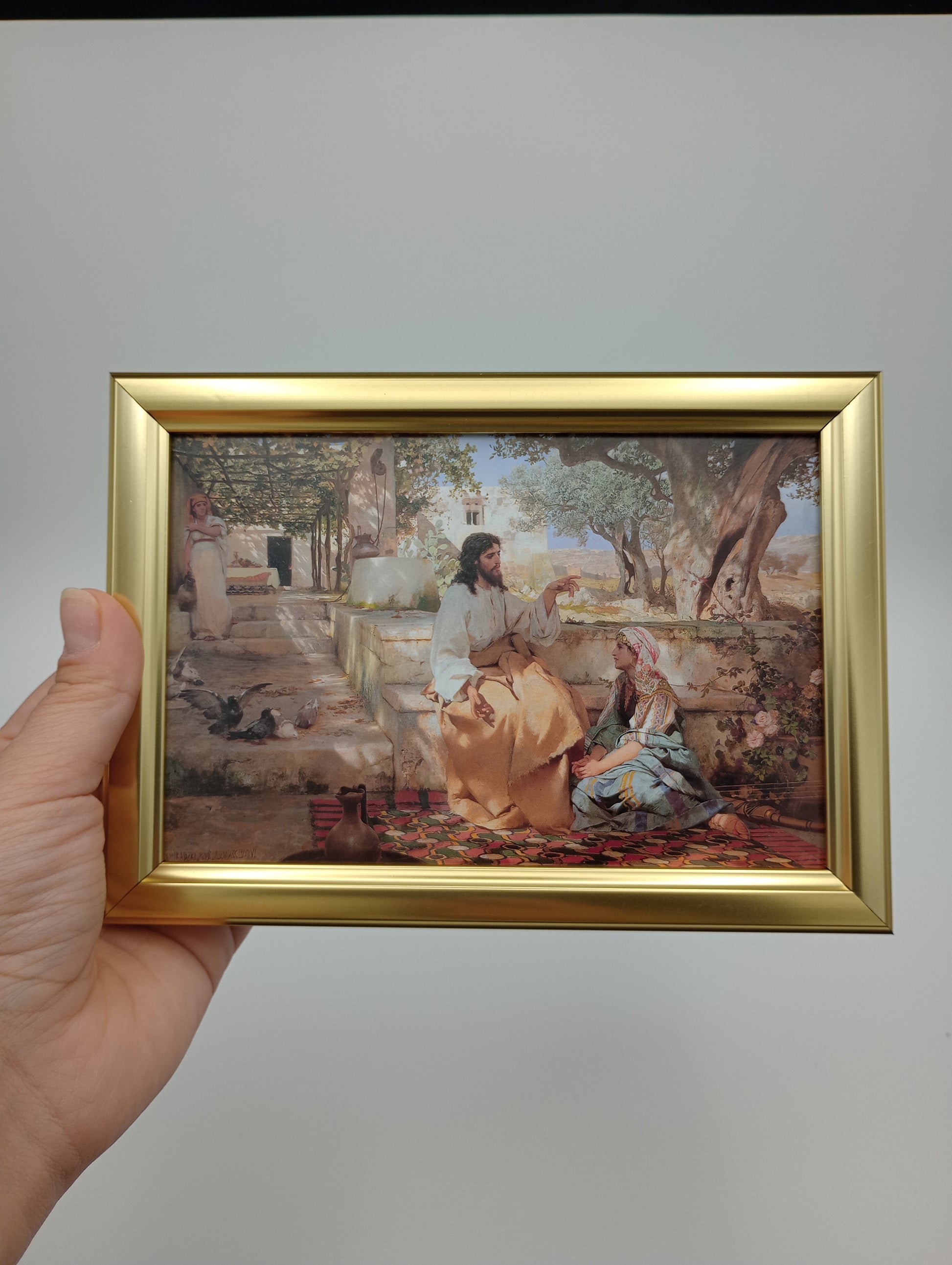 a person holding up a picture of a painting