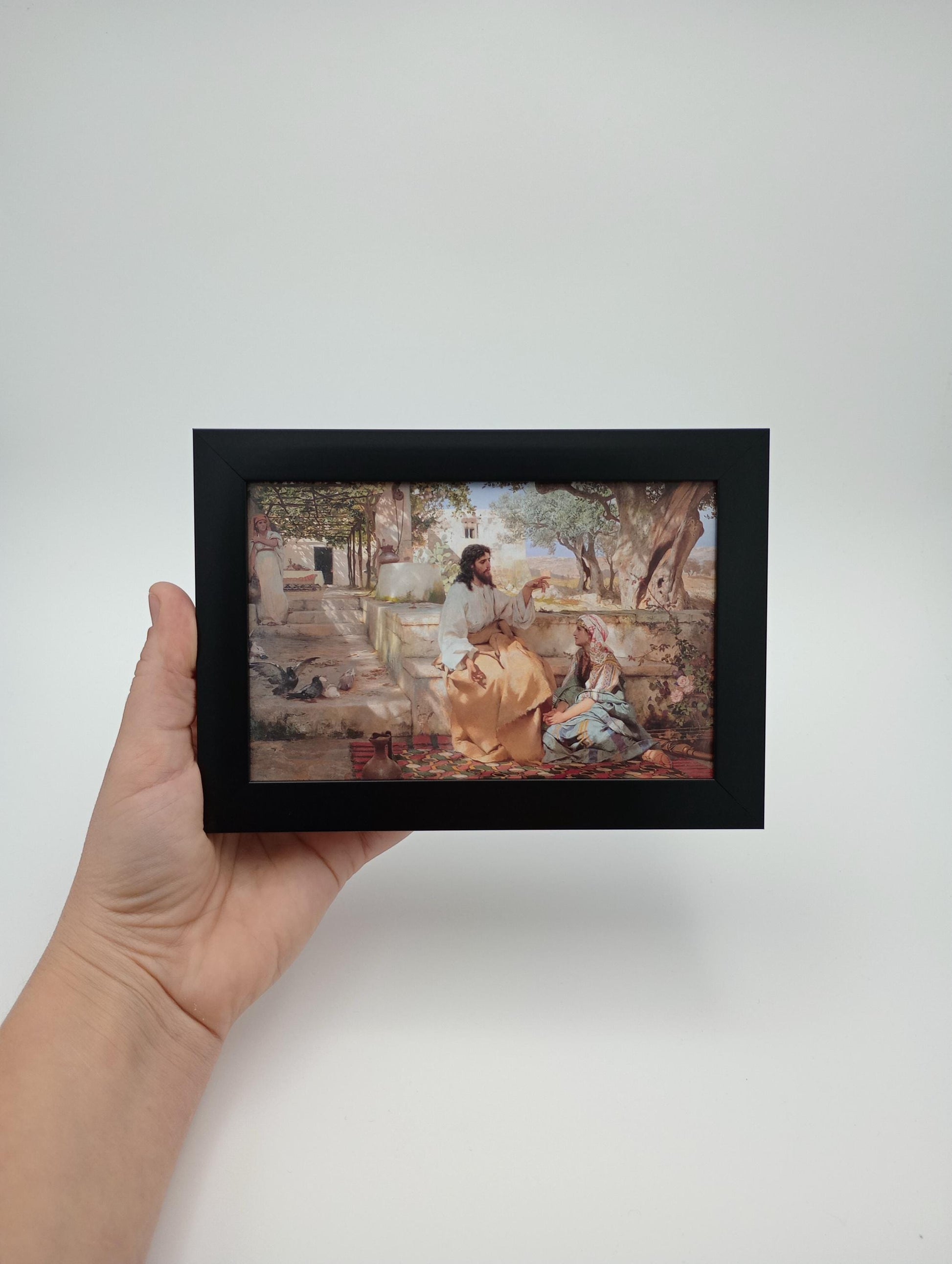 a person holding up a picture of a painting