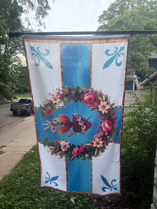 a large flag with a floral design and blue and white colors, hanging on a pole.