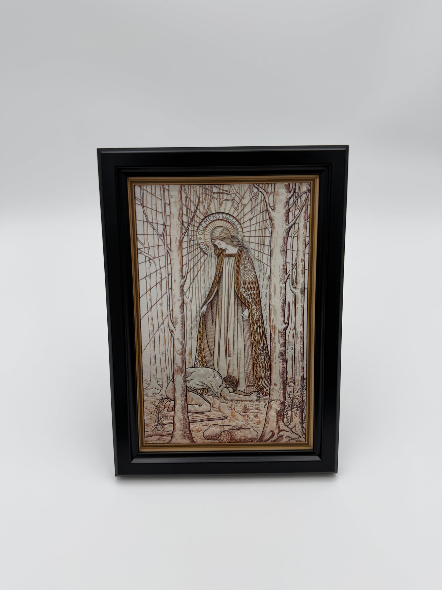 The image is a framed artwork hanging on a wall, depicting a person sitting in a boat on a river.