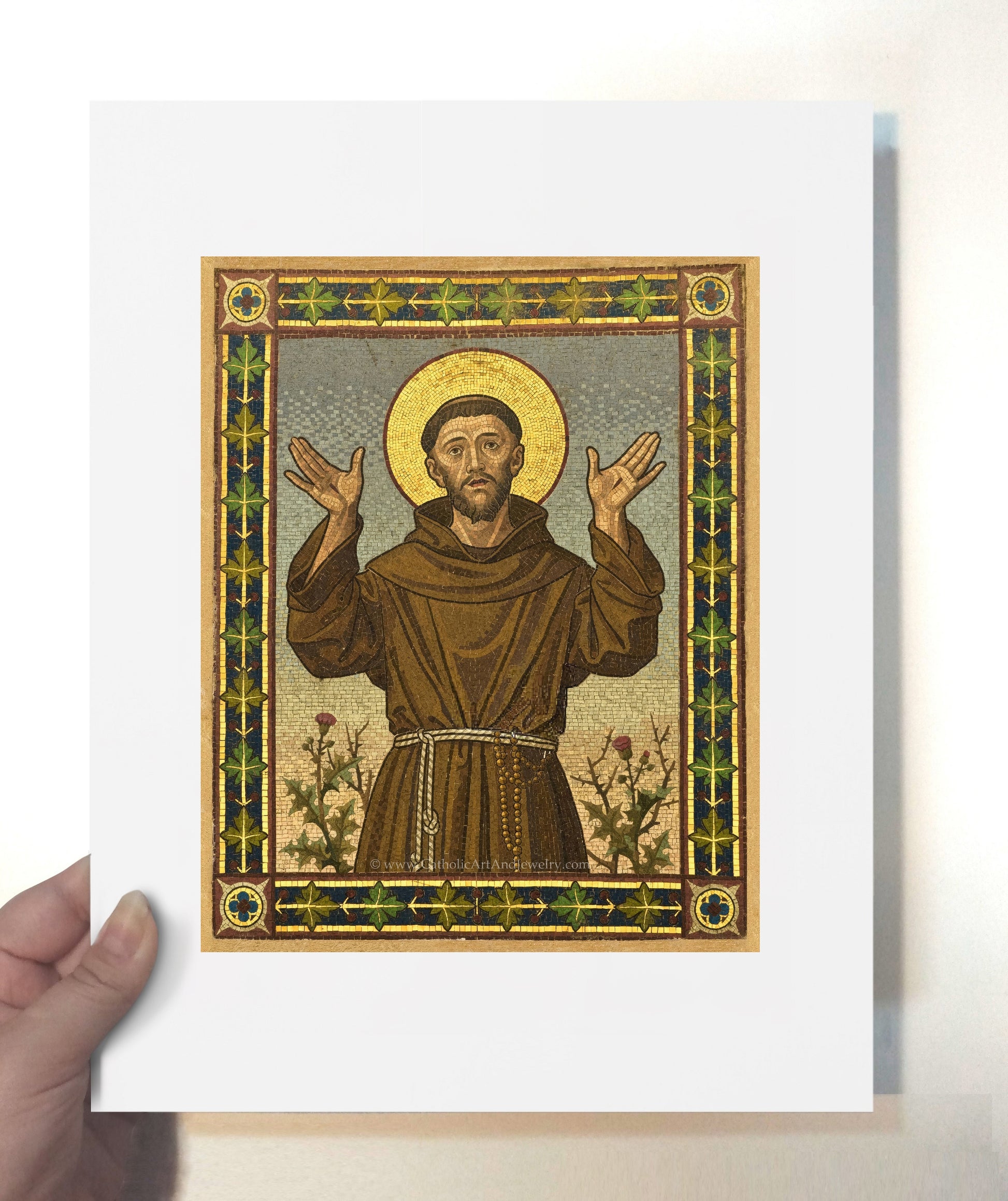 a hand holding a card with a picture of jesus