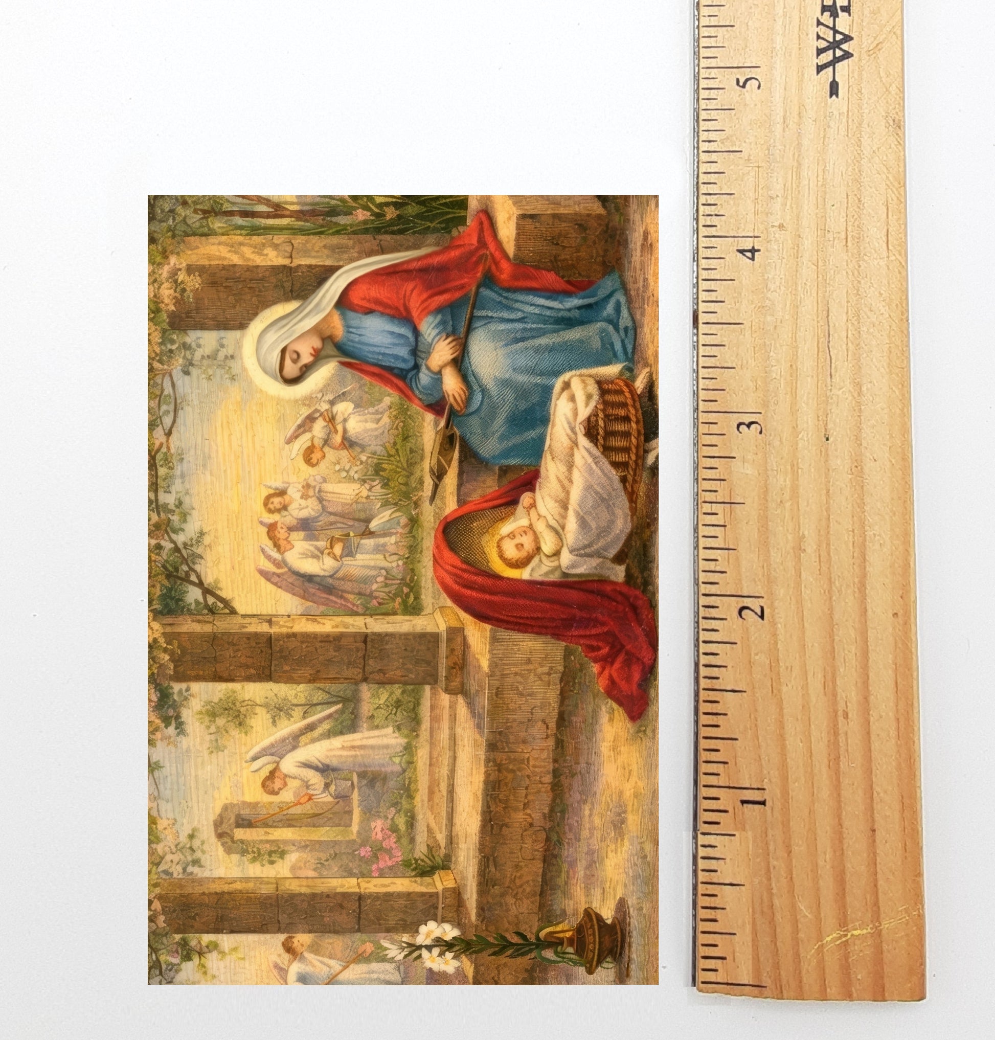 The image is a painting depicting a nativity scene with a woman in a blue dress and a baby in a basket, surrounded by angels.