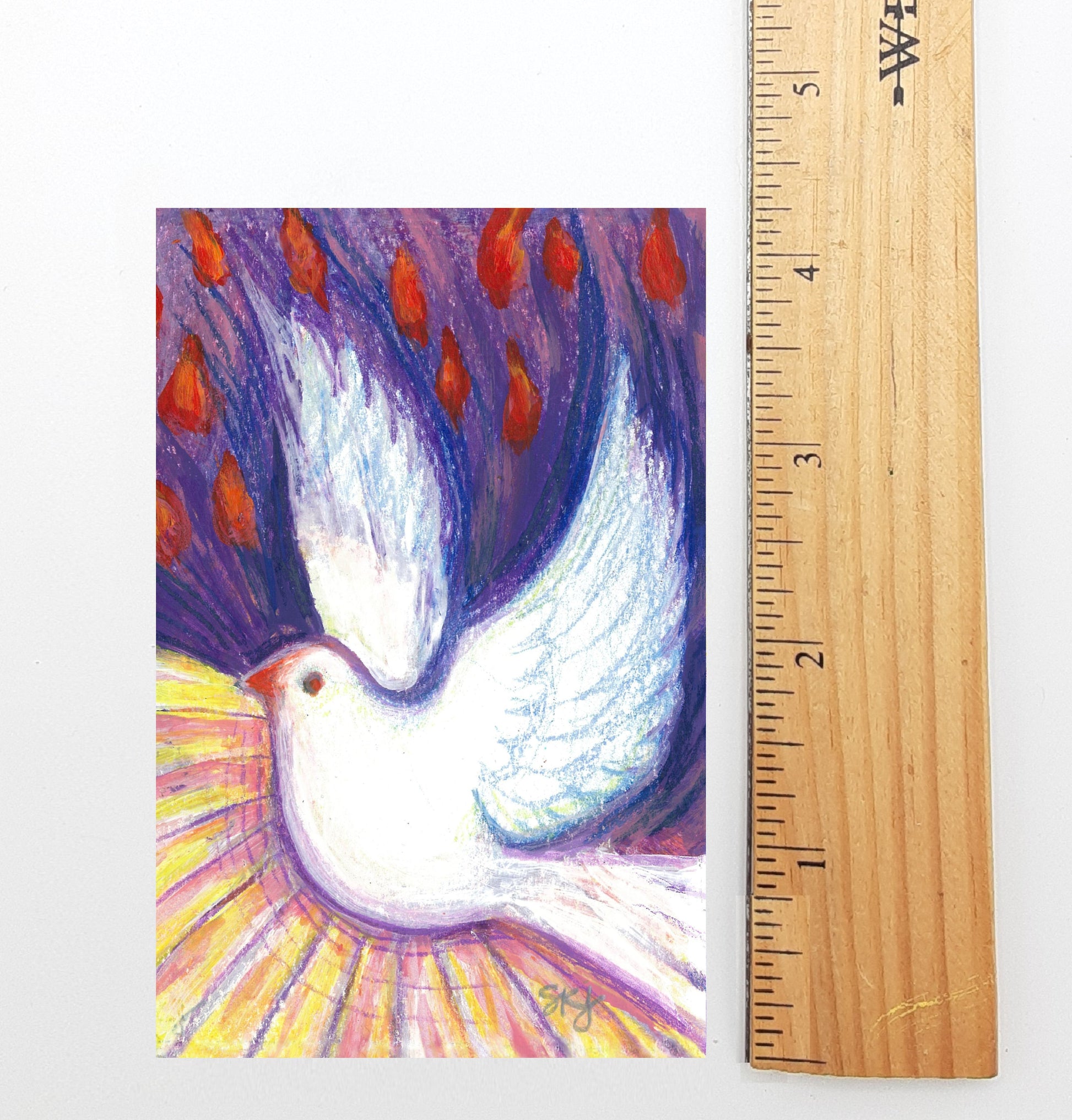 A colorful painting of a white dove in flight, surrounded by red flowers, is displayed next to a ruler for scale.