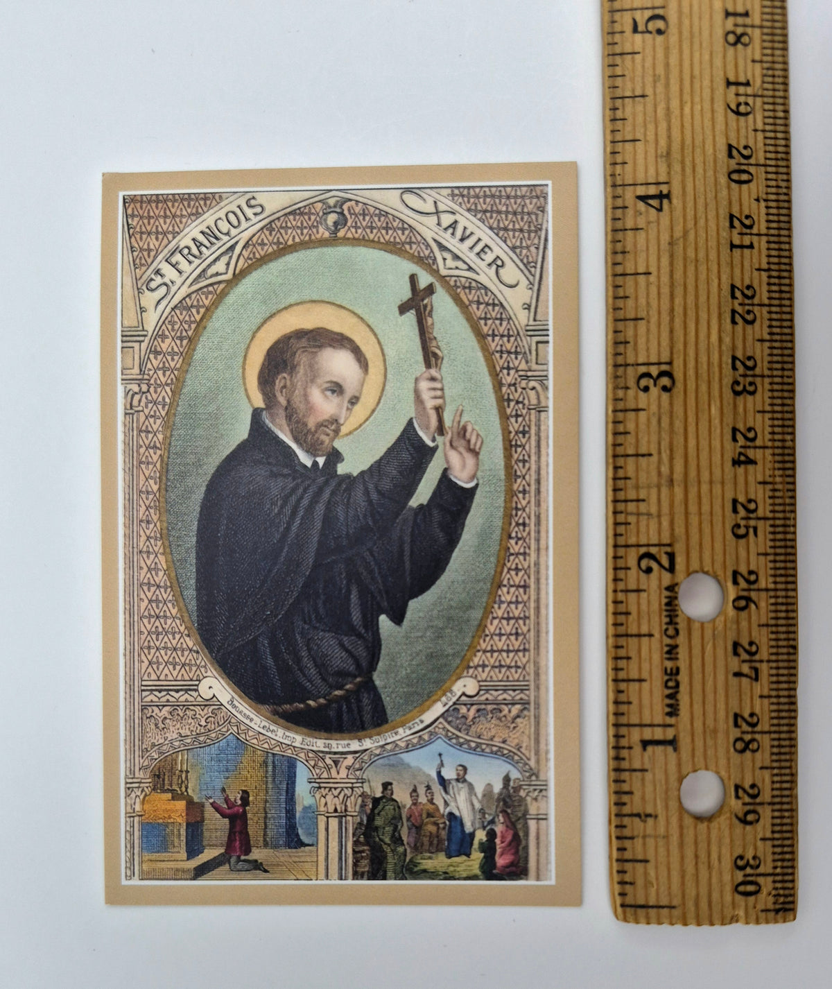 A religious card depicting St. Francis of Assisi, with a ruler next to it for scale.