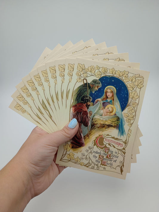 a hand holding a card with a picture of a baby jesus