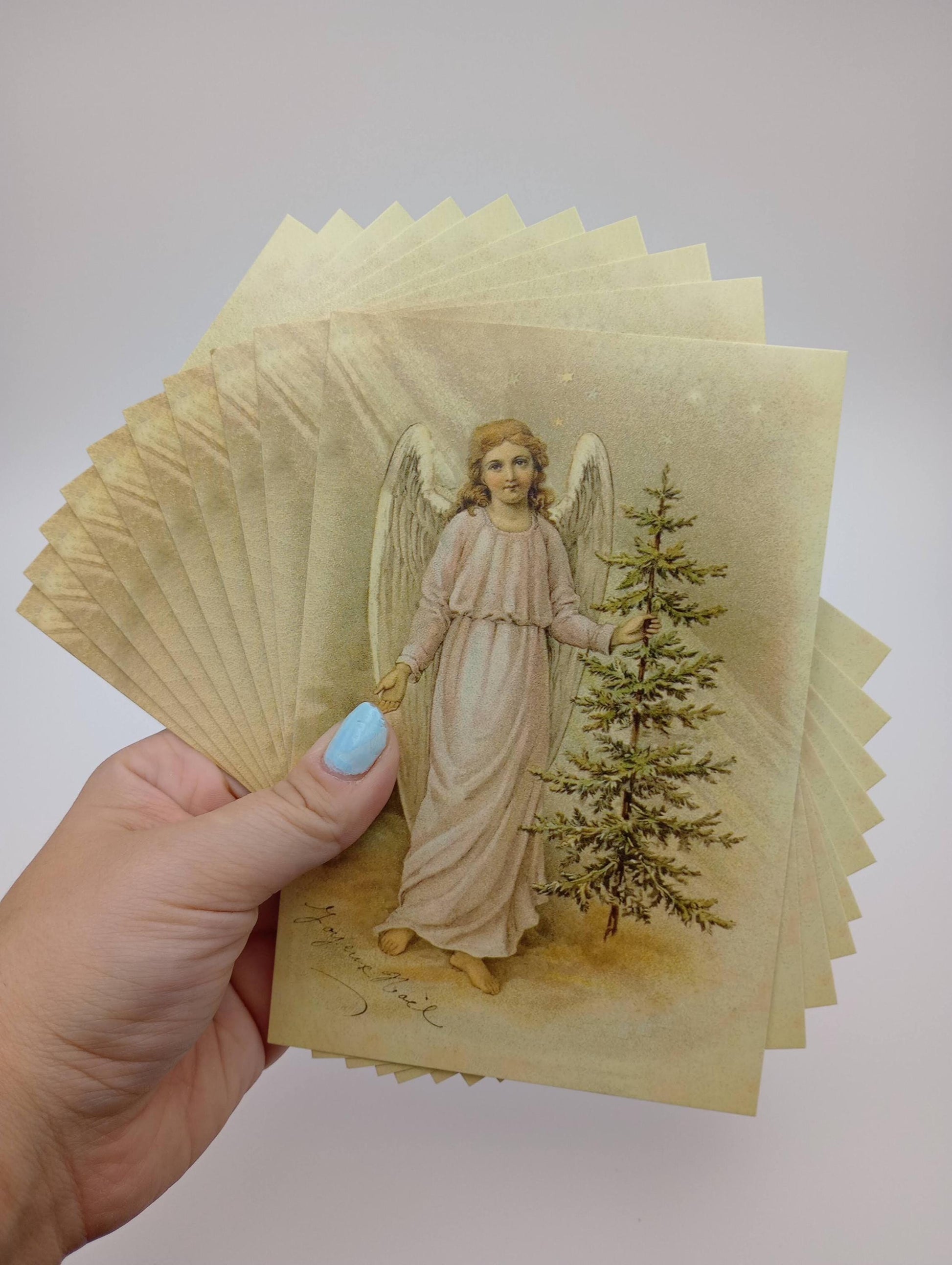 a hand holding a card with an angel on it