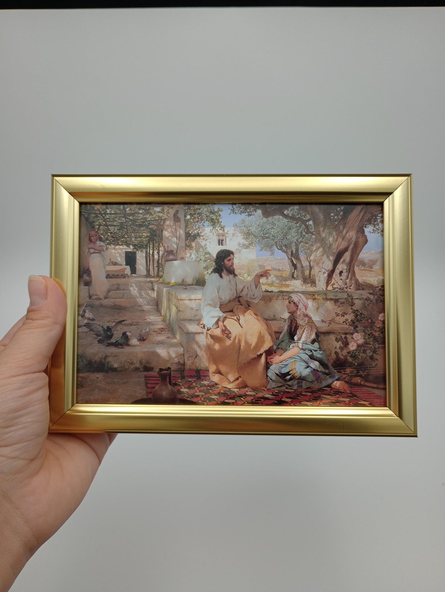 a person holding up a picture of a painting