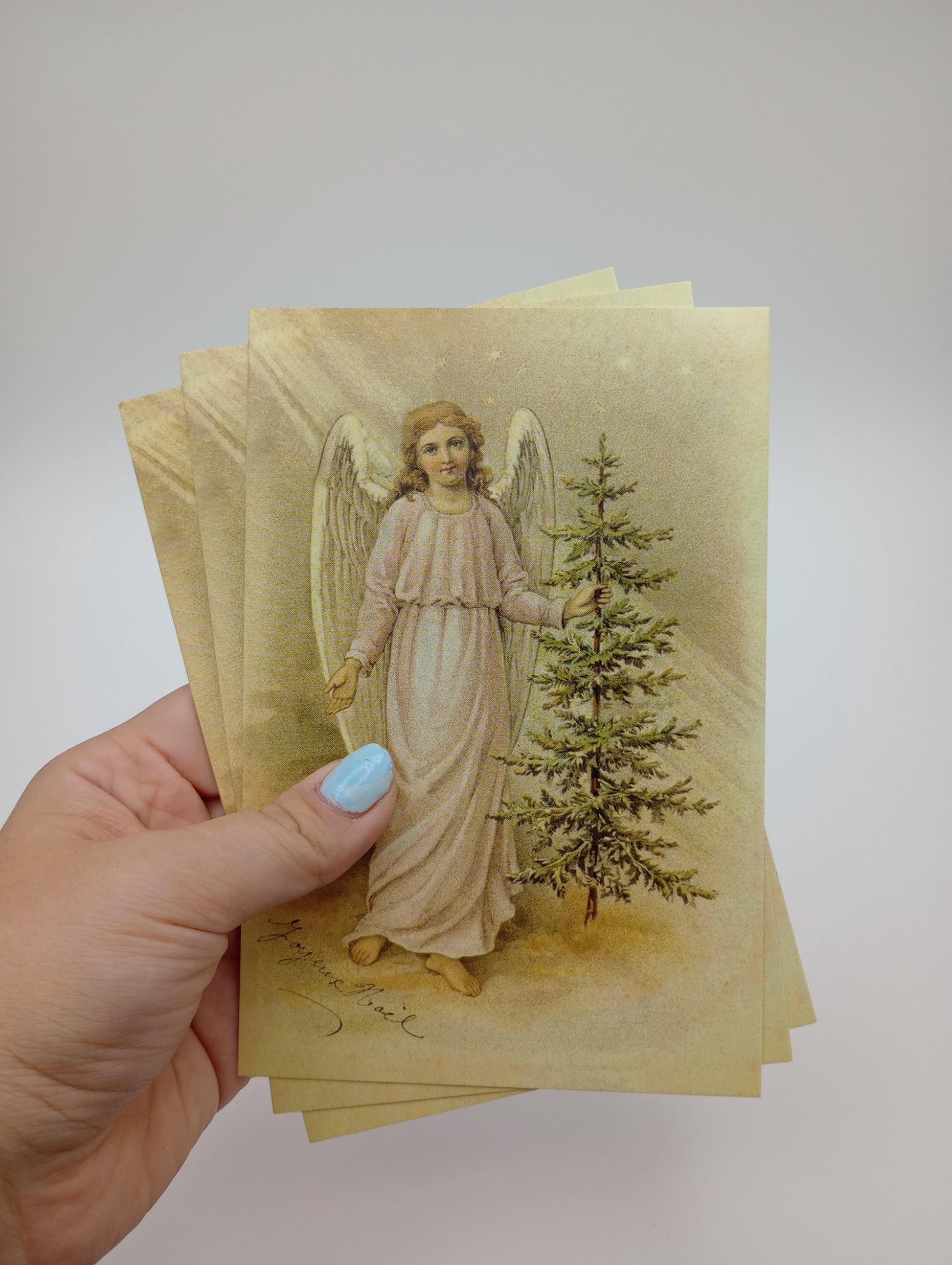 a hand holding a card with an angel on it