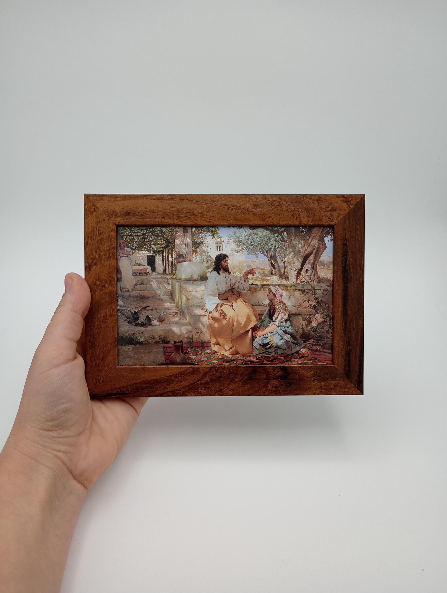 a person holding a picture in a wooden frame