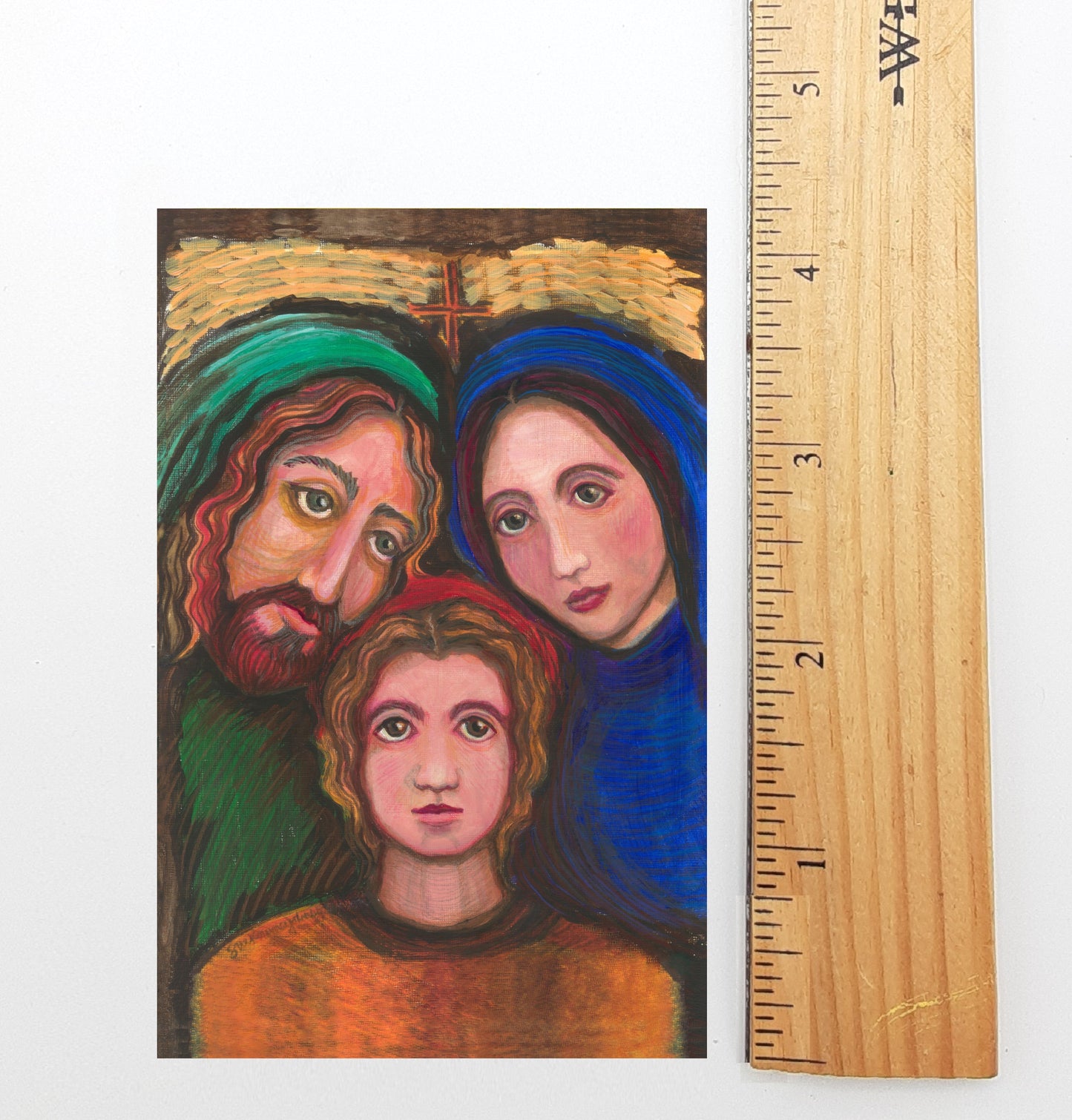 The image is a painting depicting a family of three - a man, a woman, and a child. The painting is framed by a wooden ruler, which is placed next to it.