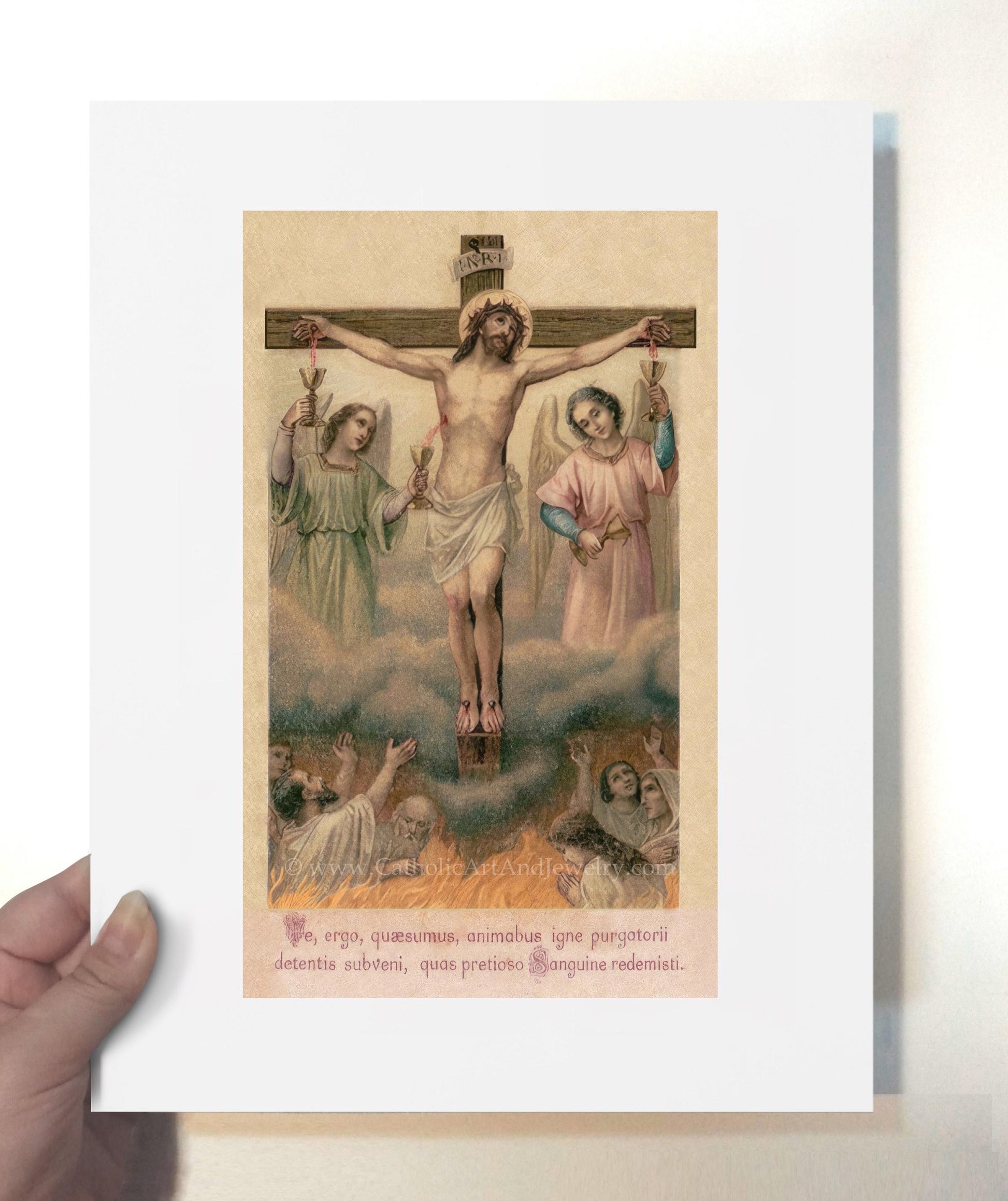 a person holding up a picture of jesus on the cross